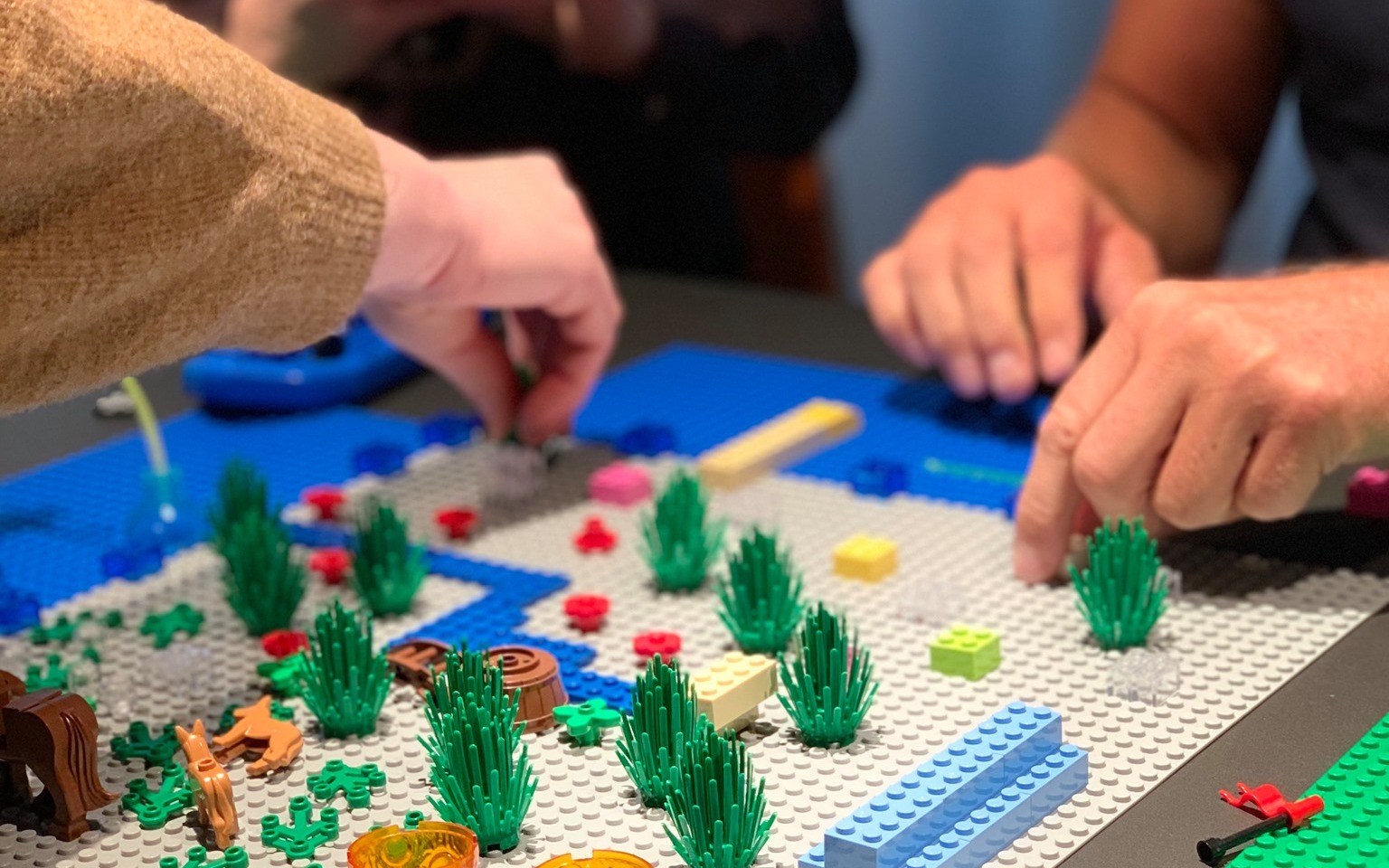 Team baut gemeinsam an LEGO Serious Play Modellen in einem Workshop