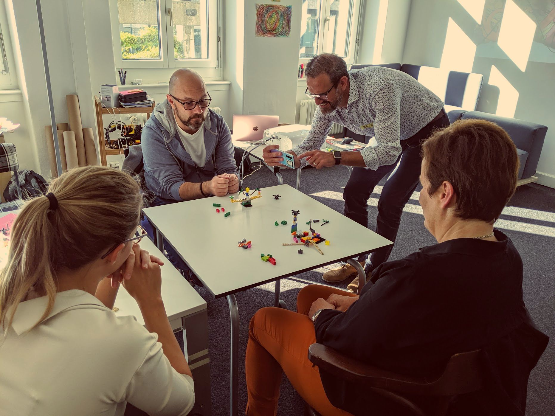 Team im Workshop vor gebauten LEGO Modellen