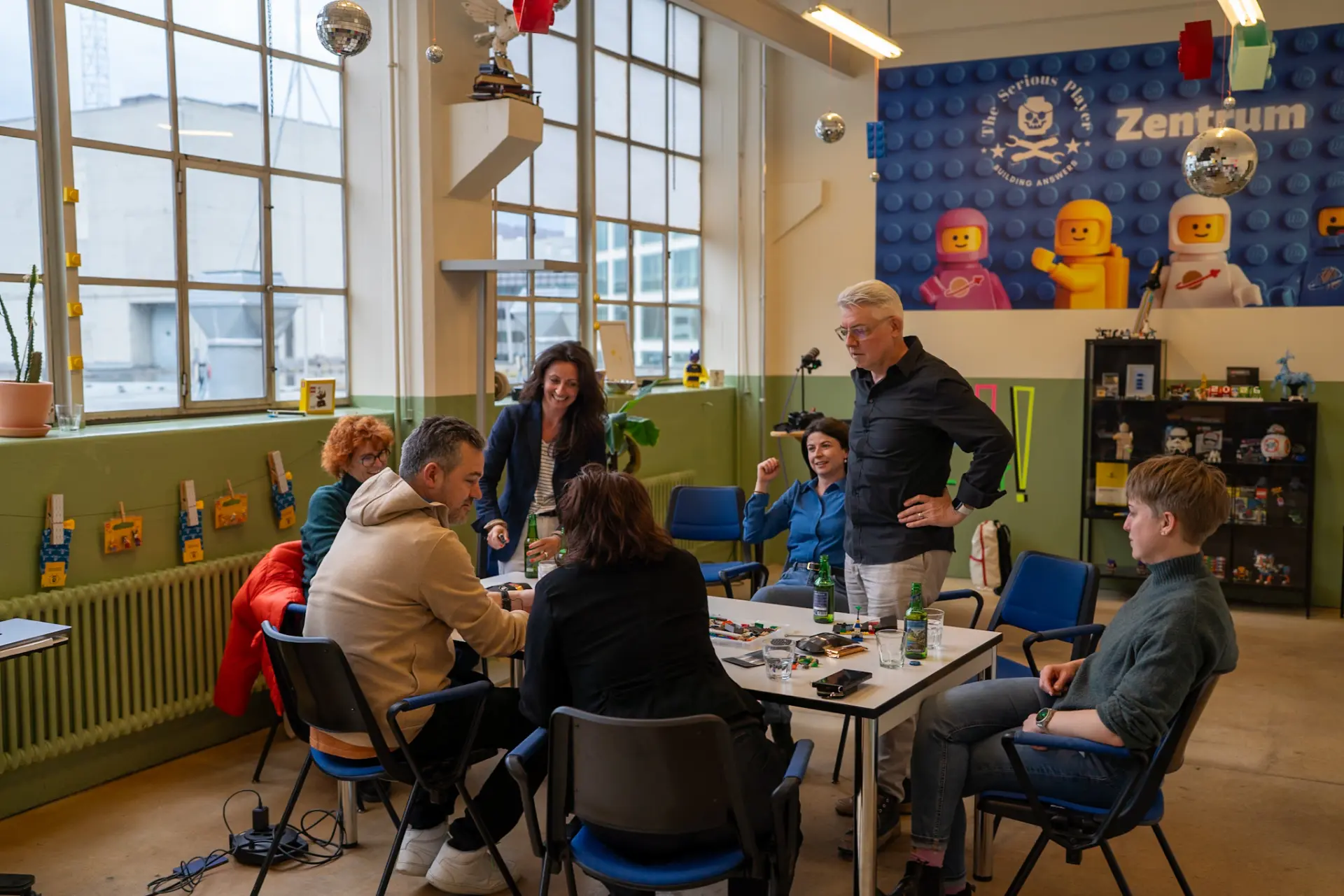 Gruppe am Tisch im Zentrum in Zürich vor der Wand mit dem Schriftzug Zentrum